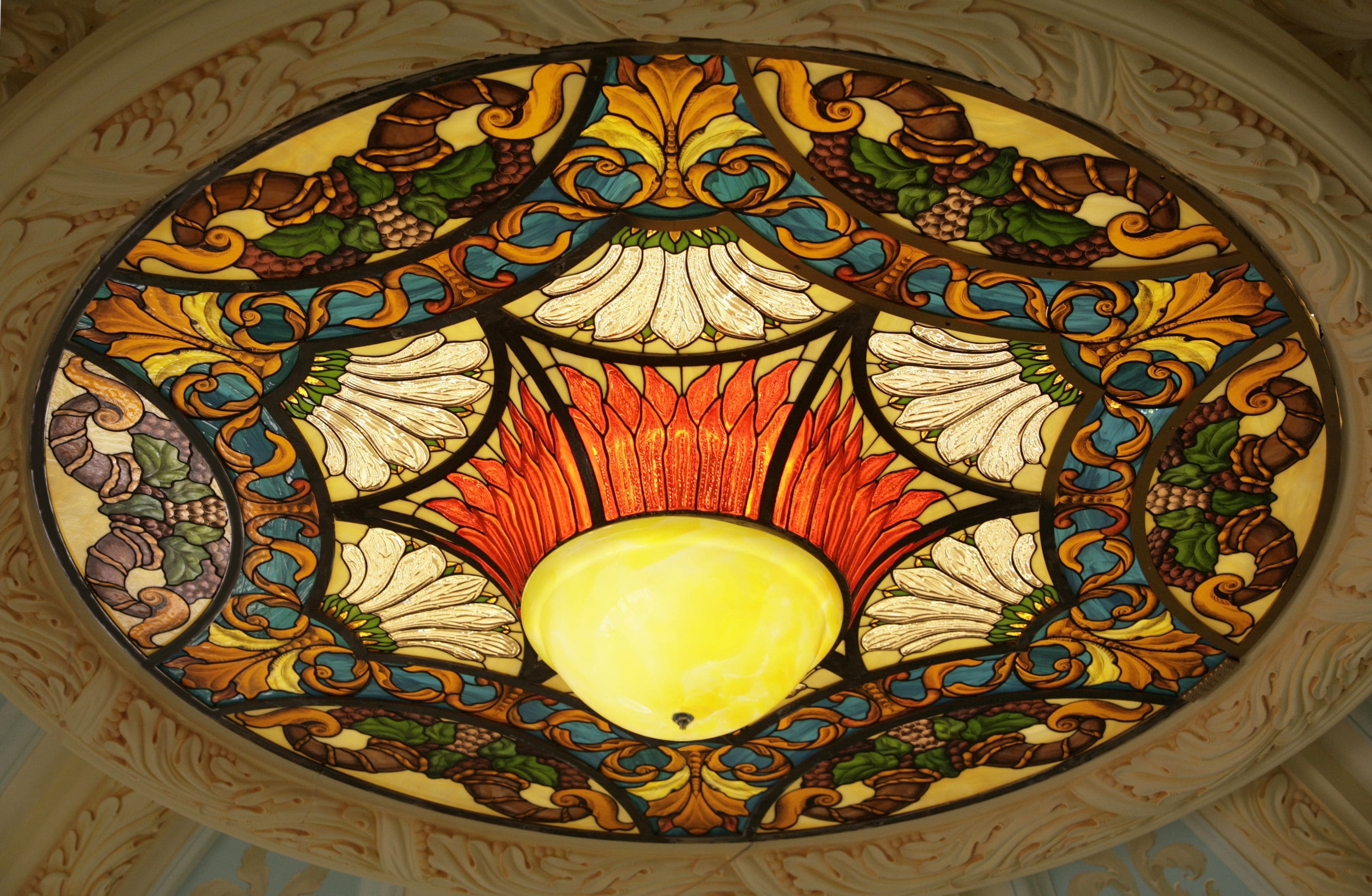 Stained glass ceiling panel with amber leaves on deep blue glass